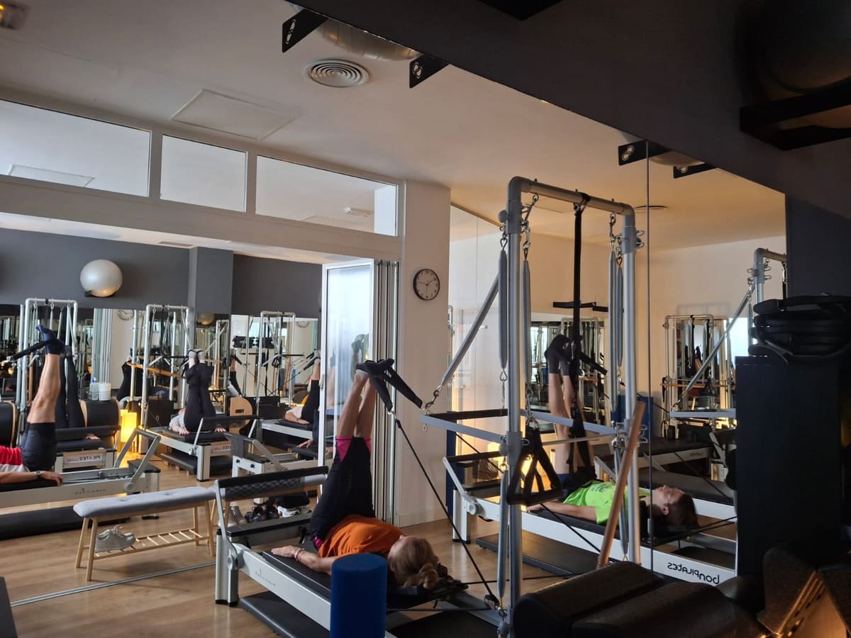 Sala amplia con reformers y torres de cadillac en Pilates Curíe